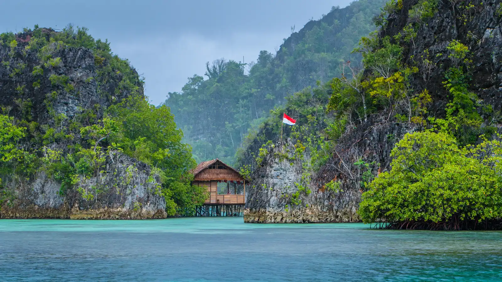 Bamboo Hut between some Rocks under Rain in Raja Ampat, Indonesia